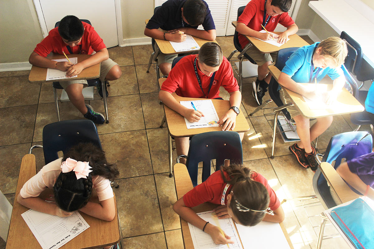 A classroom of kids sitting at desks taking a test