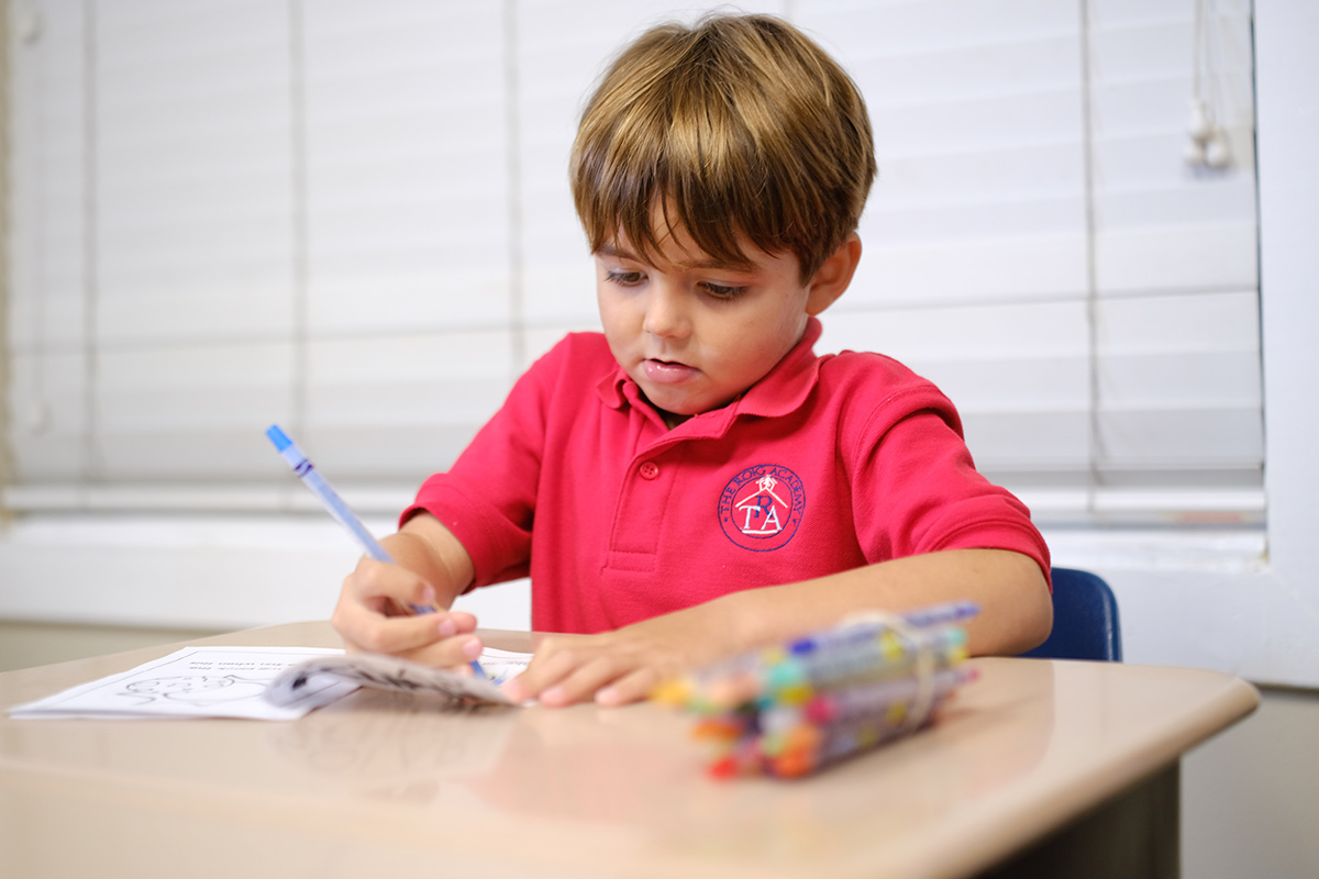 A kid using colored pencils to color