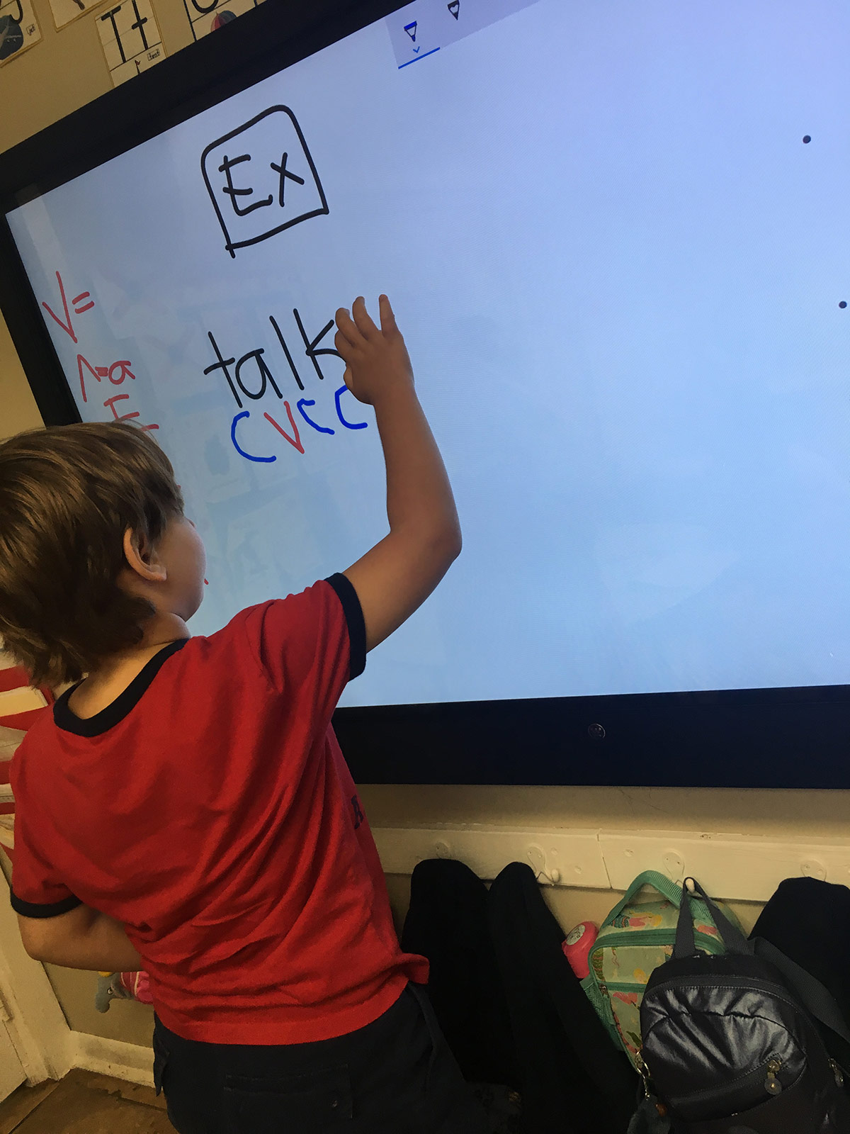 kid writing on a smart white board