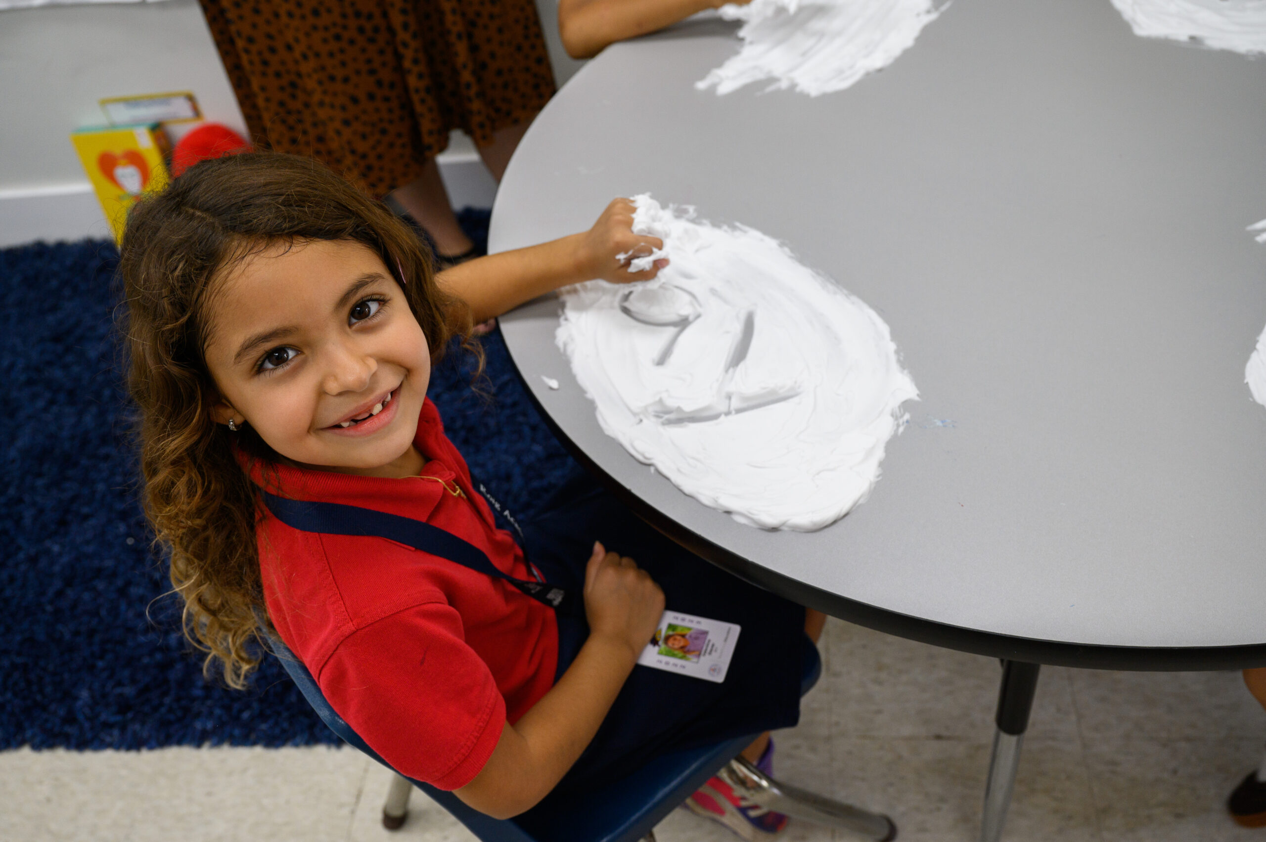 Young woman teacher teaching child in kindergarten
